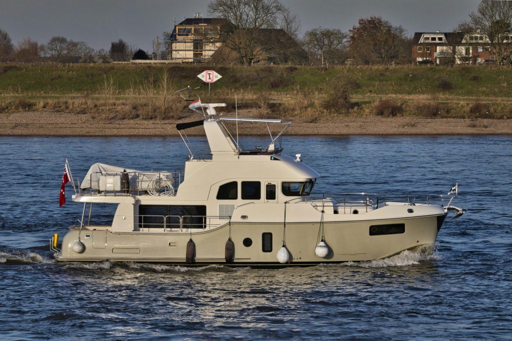 Un yacht à moteur moderne navigue sur un large fleuve.