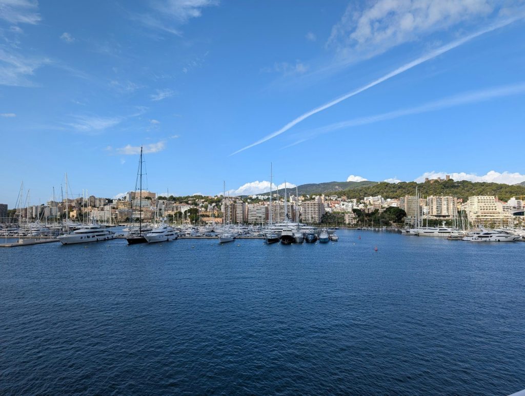 Des yachts amarrés dans un port, avec la silhouette de la ville en arrière-plan.